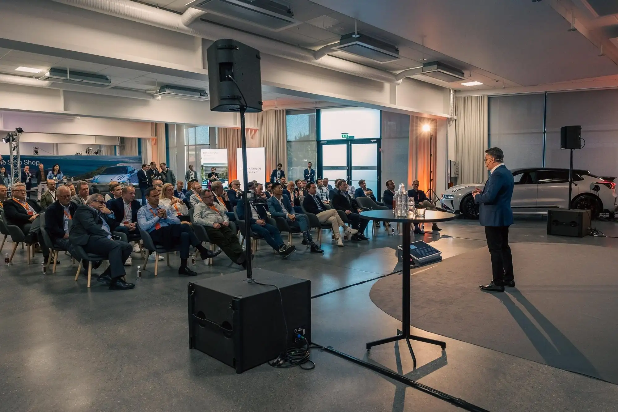 Publik lyssnar på en talare i en ljus eventlokal