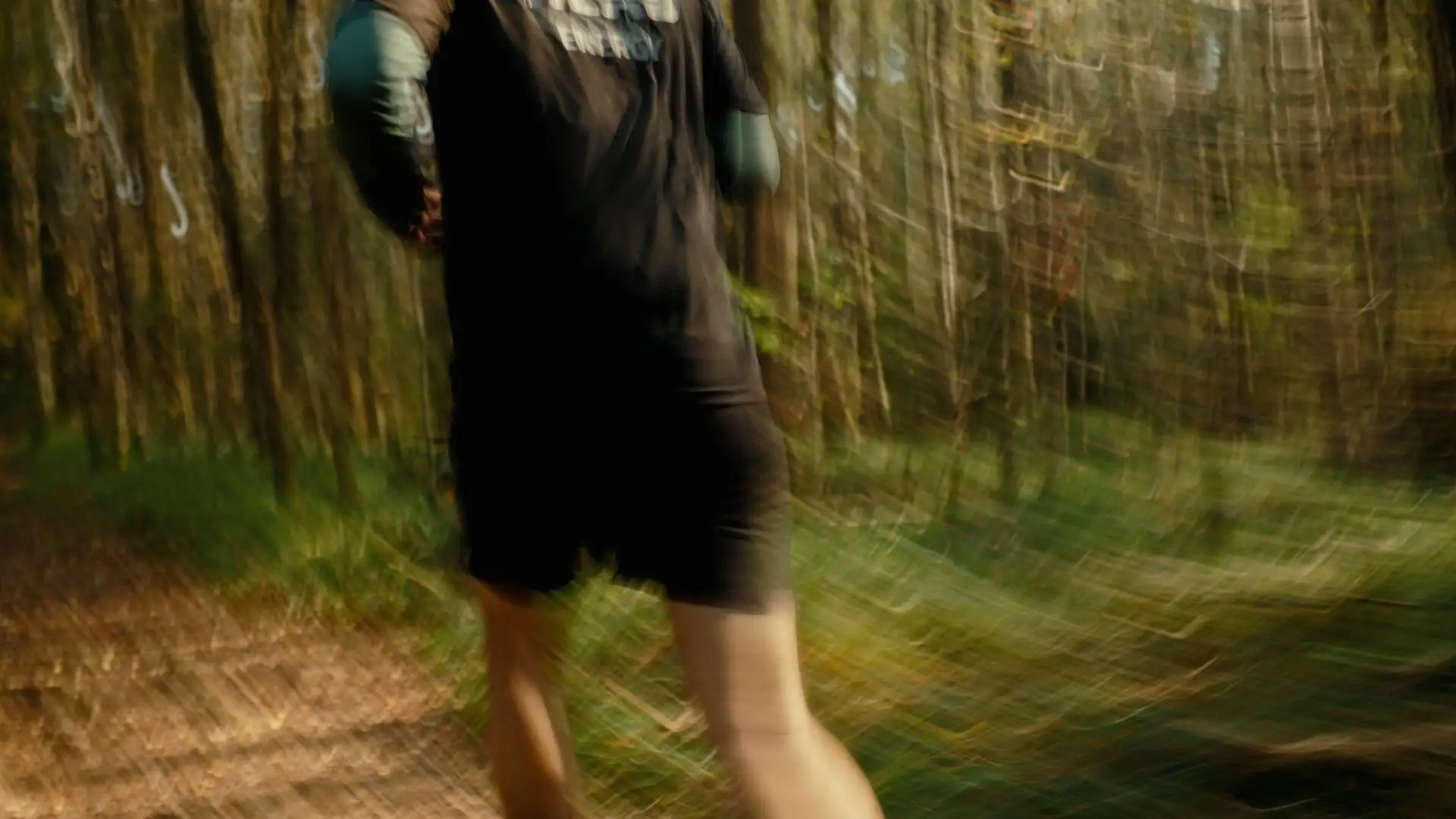 Löpare i rörelseoskärpa genom en skog