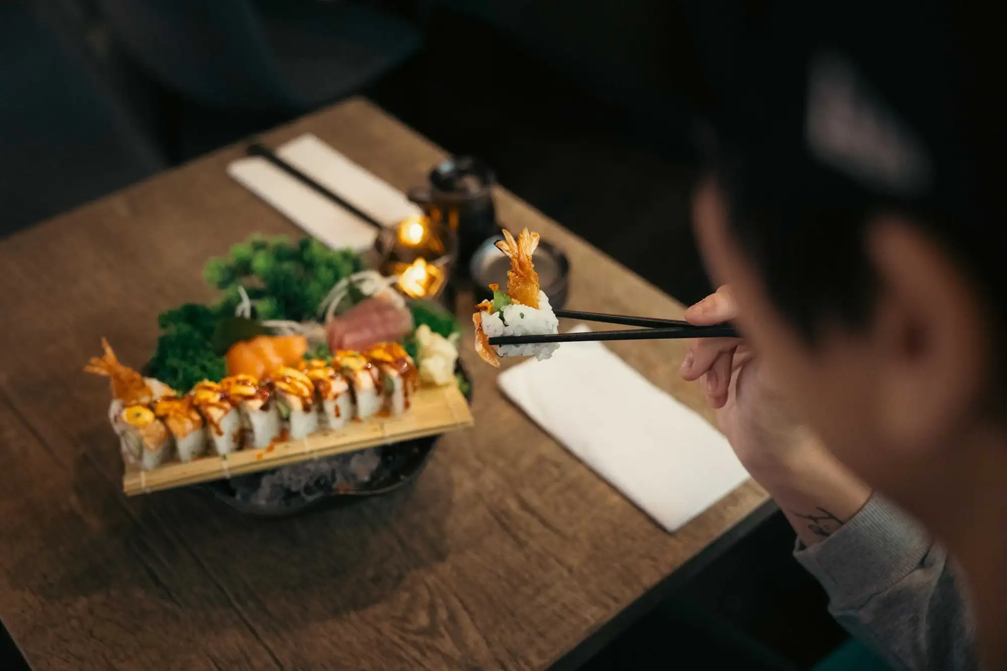 Sushi på bräde bredvid en gäst vid ett restaurangbord