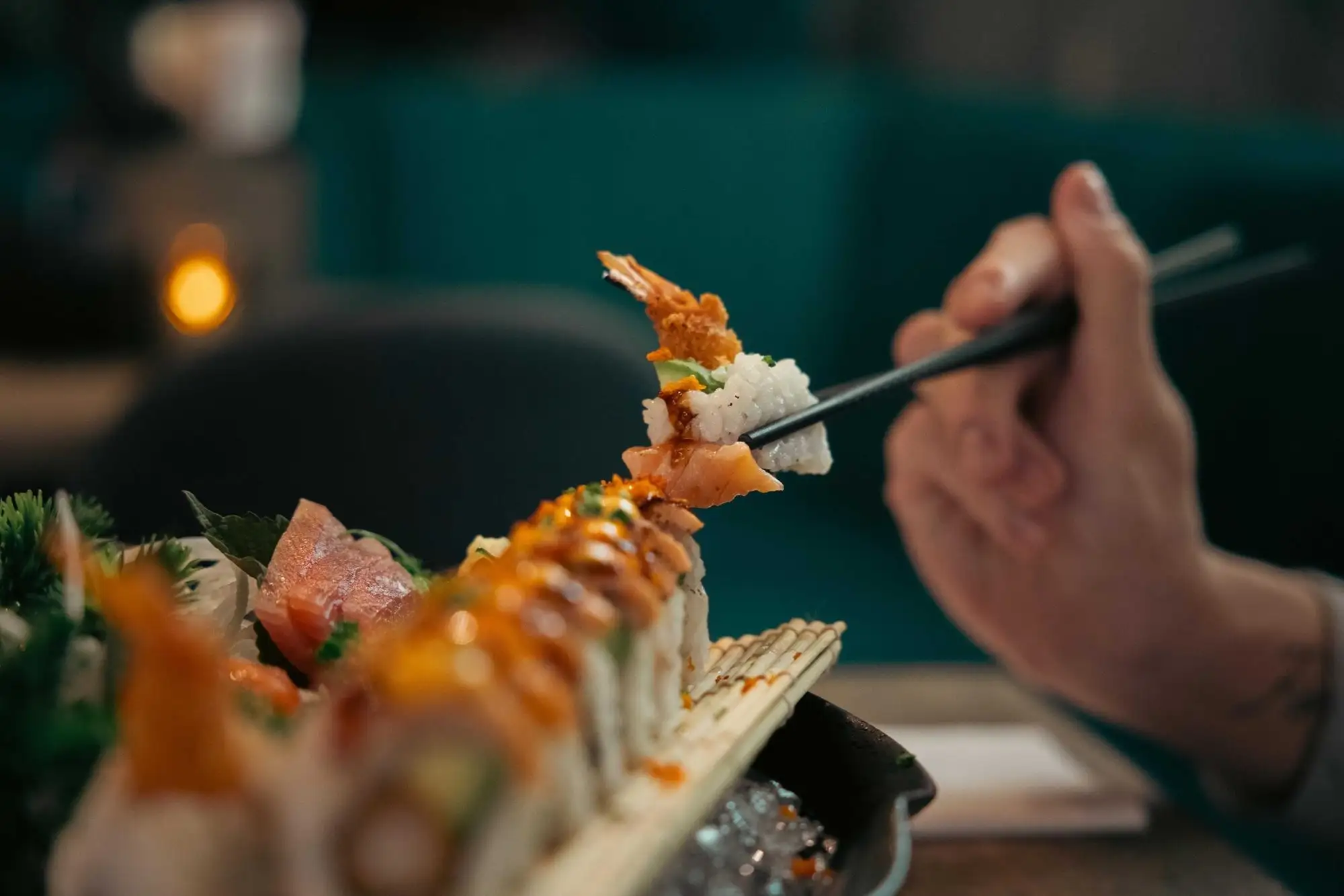 Sushi lyfts med pinnar från ett bräde