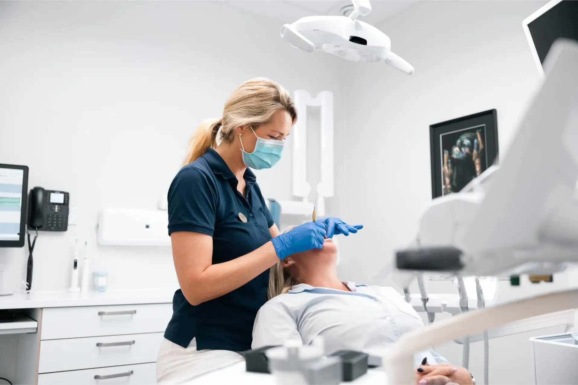Tandläkare och patient i ett ljust behandlingsrum