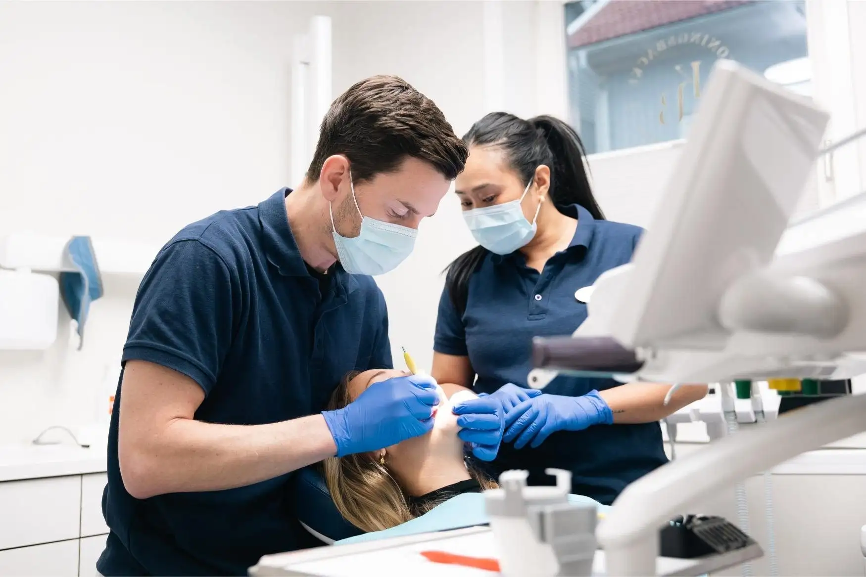 Tandläkare och assistent behandlar en patient